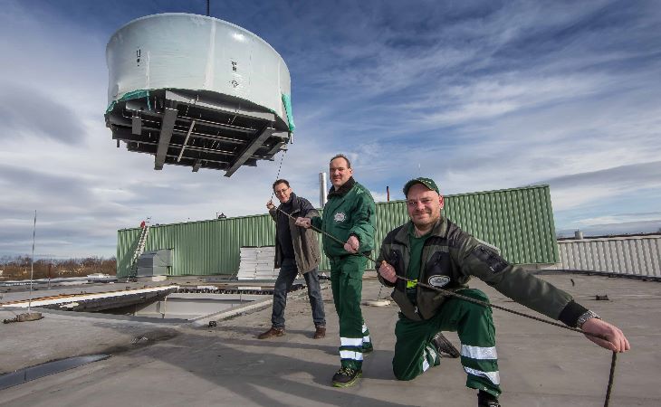 Oberbrauer Michael Pötzl, Elektromeister Michael Dreikorn und Technik-chef Rüdiger Senf (von vorn nach hinten) packen mit zu, als der Läuter-bottich per Kran ins künftige Sudhaus gehoben wird. Foto: Sternquell / Igor Pastierovic