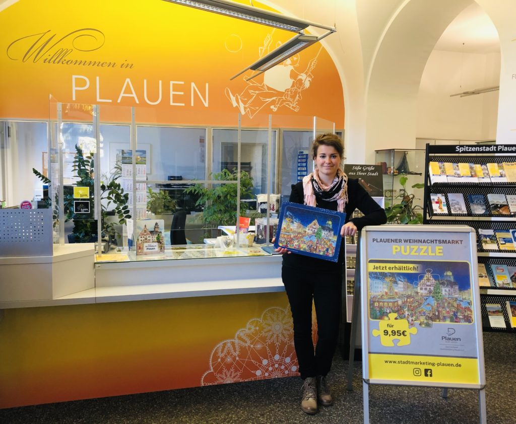 Auf dem Bild ist Anika Seidel von der Tourist-Information im Plauener Rathaus mit dem Weihnachts-Puzzle zu sehen. Hier ist das schöne Geschenk ab sofort erhältlich. Foto: Stadtmarketing Plauen