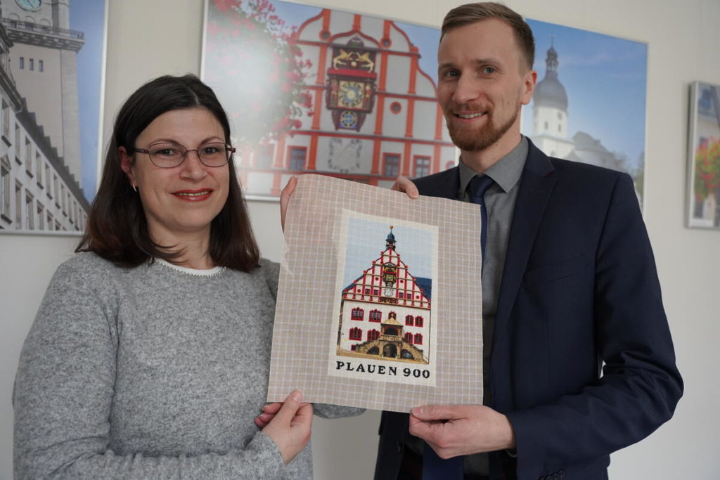 Nicoletta Seidel übergibt ihre Stickerei an Bürgermeister Tobias Kämpf. Foto: Stadt Plauen