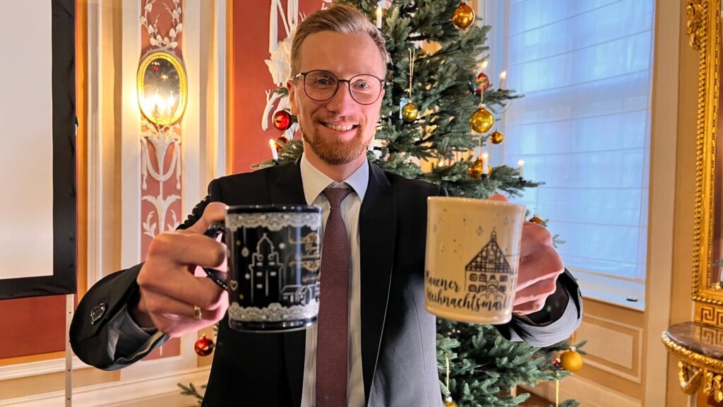 Bürgermeister Tobias Kämpf präsentiert die neuen Tassen für den Plauener Weihnachtsmarkt. Foto: s. Höfer