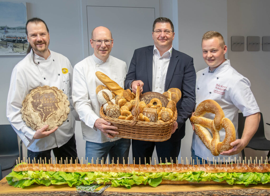 Bäckermeister Torsten Aust, Obermeister Jörg Schürer und Bäckermeister Andre Knüpfer (von links nach rechts) übergeben an Landrat Thomas Hennig (2. von rechts) Brotpräsente. Foto. Landratsamt