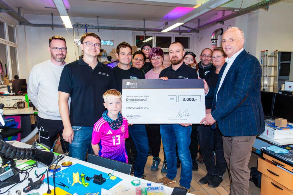 Felix Eckner, Holger Weber, André Fiedler (Vorstände Sternenlabor e.V.); ganz rechts Dr. Lutz Neumann (erfal-Stiftung). Im Hintergrund Mitglieder des Sternenlabor e.V.
Foto: Sternenlabor e.V.