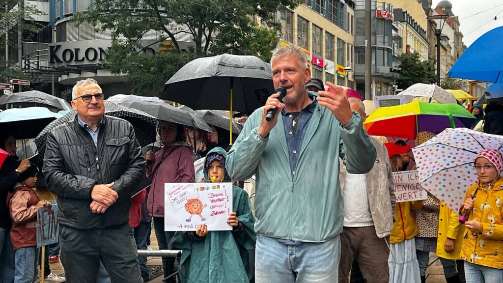 Hartmut Stief - Pfarrer der St.-Michaelis-Kirchgemeinde Plauen betet mit den Teilnehmern vorm Landratsamt.